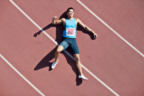 Guide 101:Injury Prevention Strategies for Active Individuals 1 Tired runner laying on track After injury